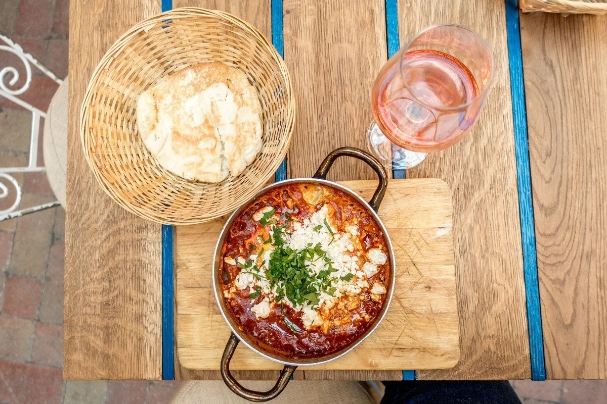 Shakshuka, bread, and wine on table