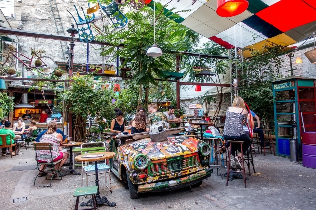 People sitting at a table inside a car covered with spray paint