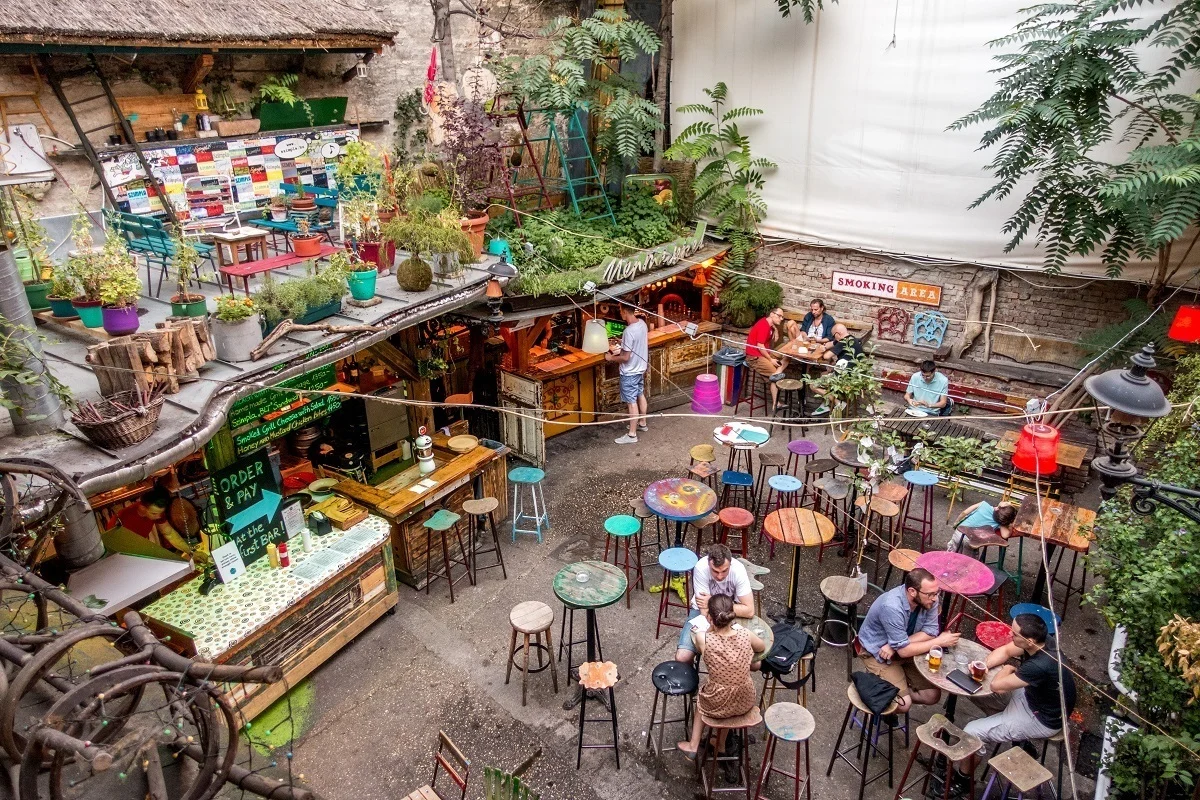Colorful courtyard filled with plants and people sitting at tables