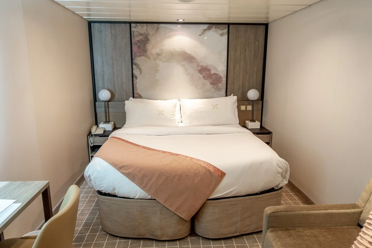 Bed and chairs in an interior stateroom on the Celebrity Summit