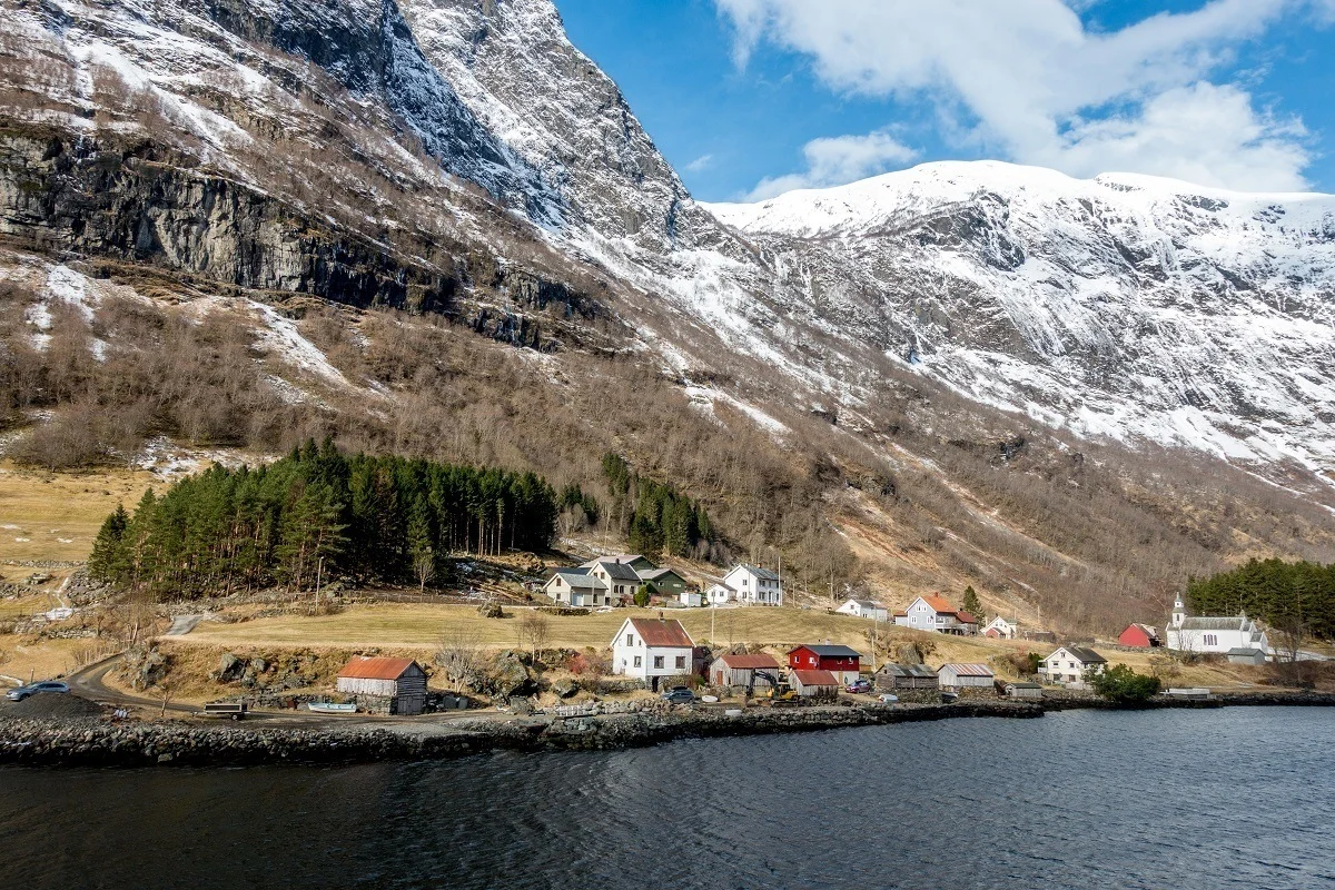 Houses along the water beside snow-covered mountains