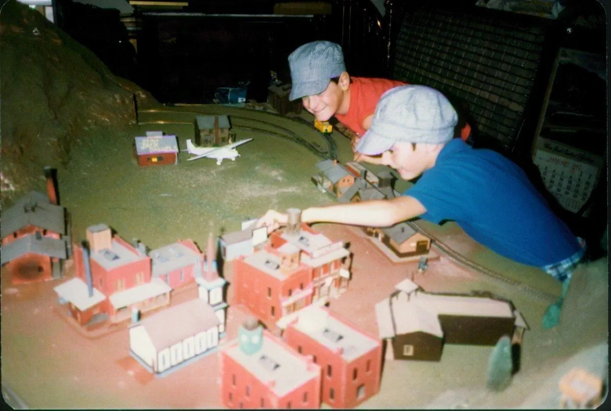 Lance and his friend Peter working on a model train set in 1984