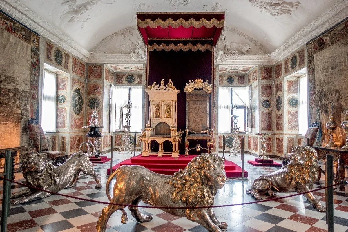 Royal thrones guarded by large silver lion statues