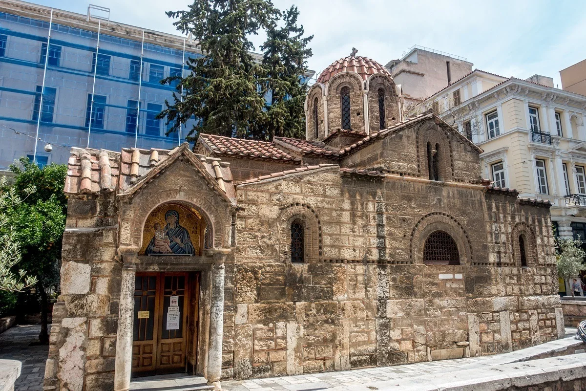 Small Church of Panagia Kapnikarea surrounded by modern buildings
