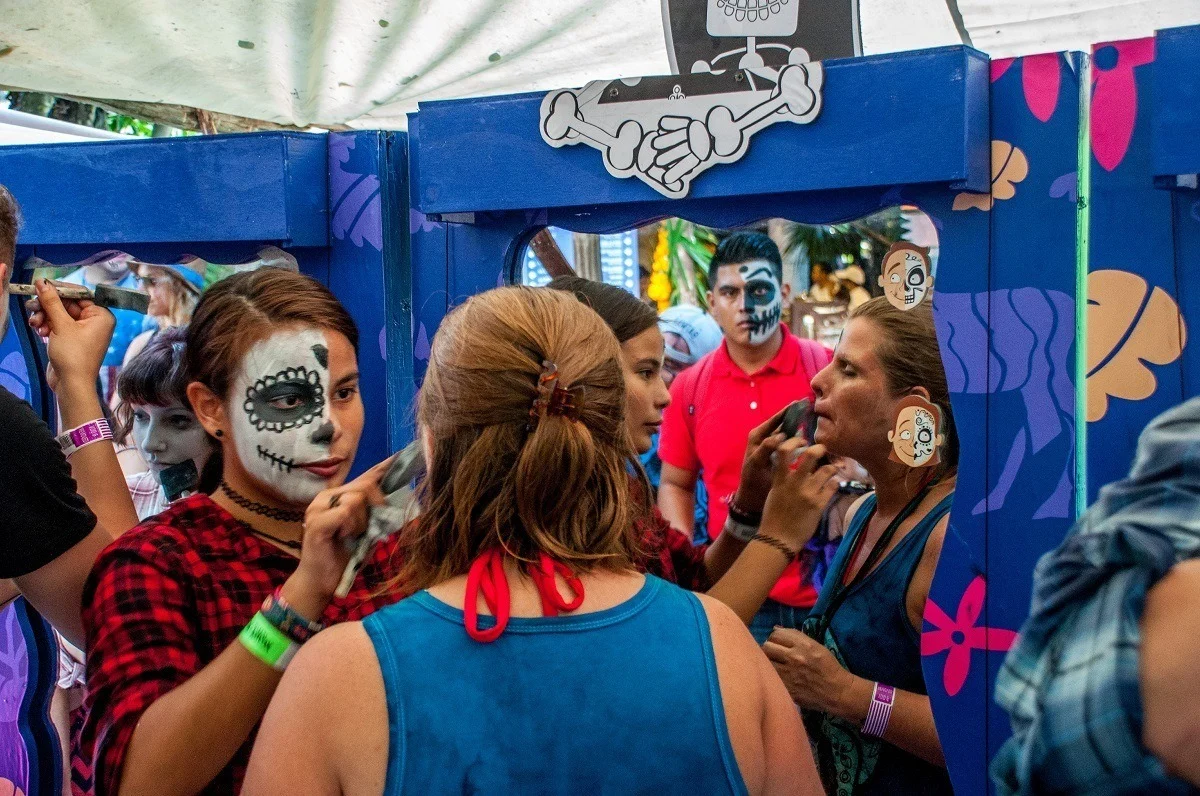 People putting on Day of the Dead face paint
