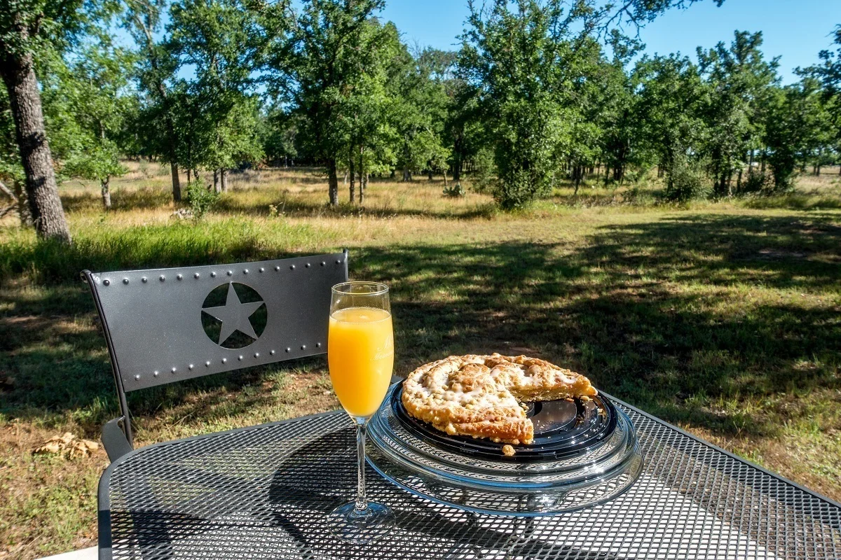 Pie and glass of orange juice on a table outside