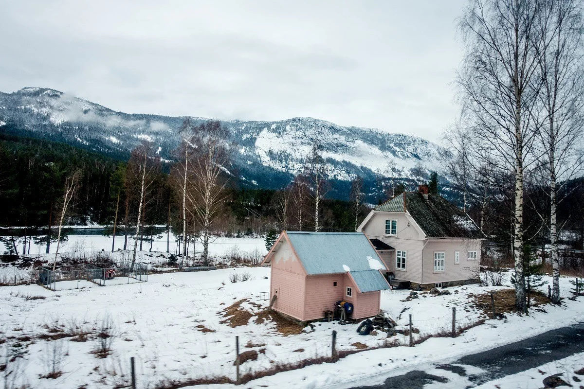 Pink houses in the Norwegian countryside covered in snow.