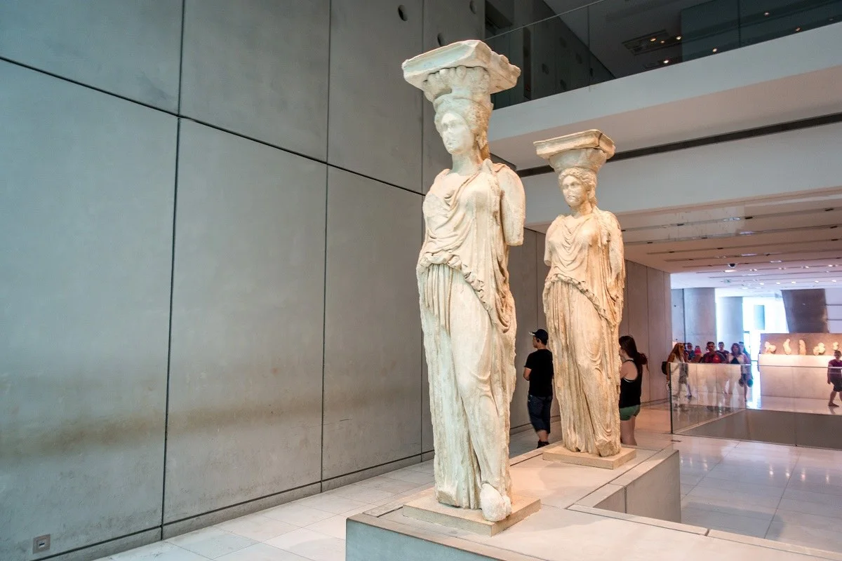 Marble statues of women displayed in a museum 