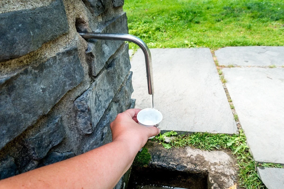 Cup being filled with water under a spigot