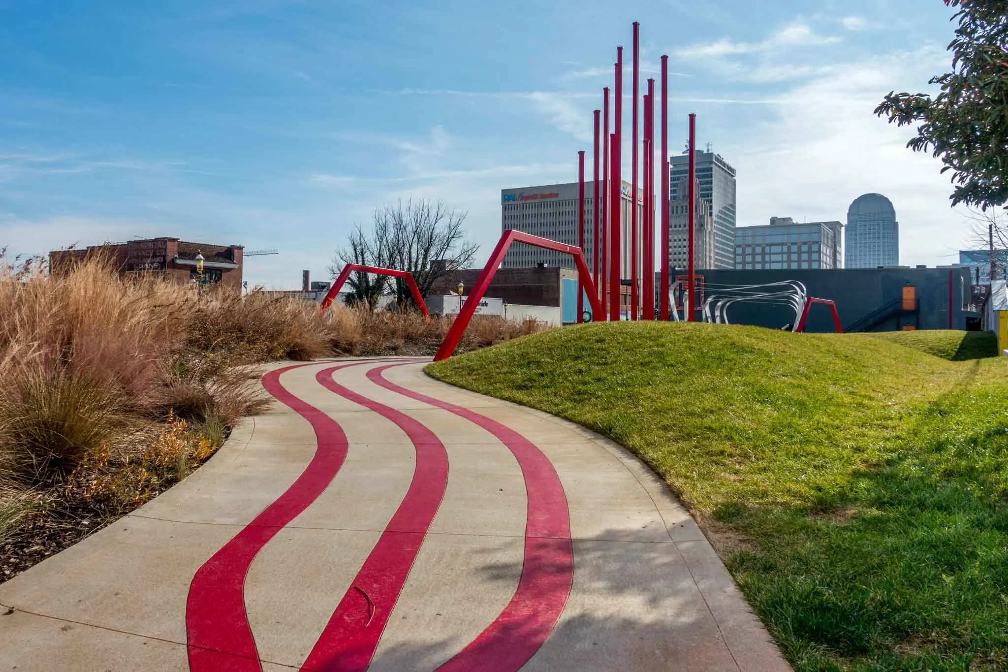 Outdoor artworks including a red sidewalk trail leading to a red sculpture