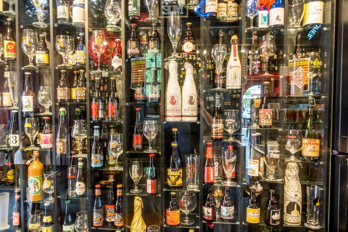 Wall of beer bottles and glasses.