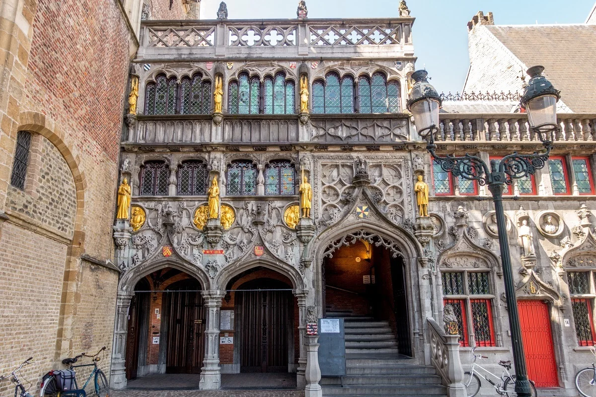 Stone exterior of a church with gold statues and stained glass