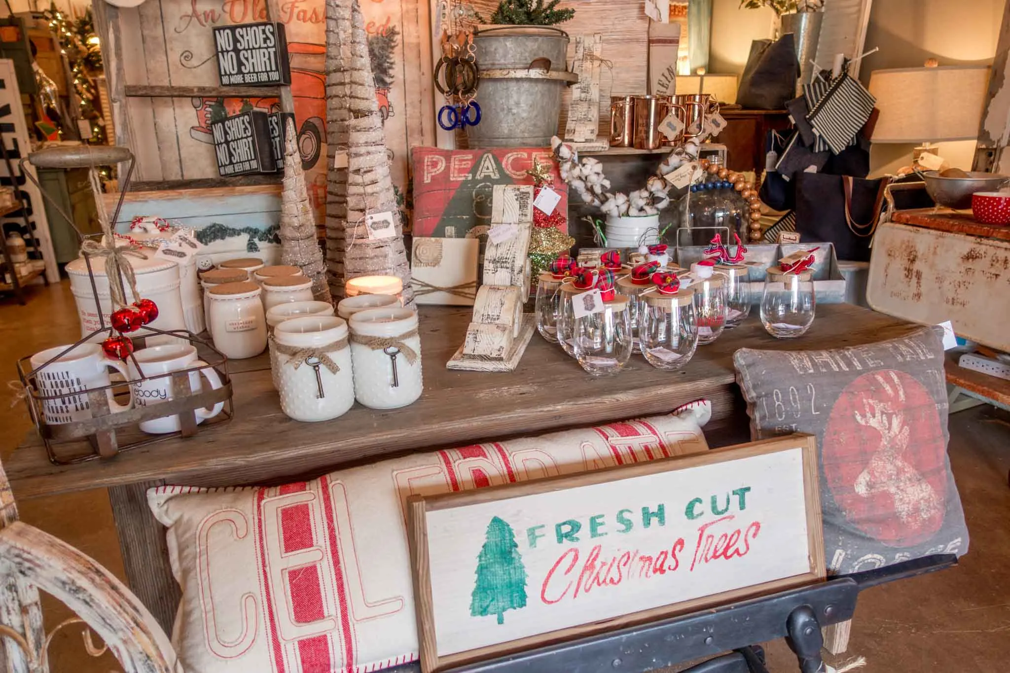Mugs, pillows, and Christmas items for sale in a store