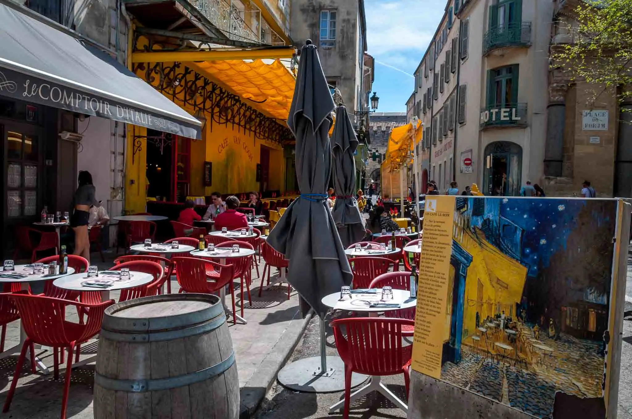 Sidewalk cafe alongside a painting of the site.