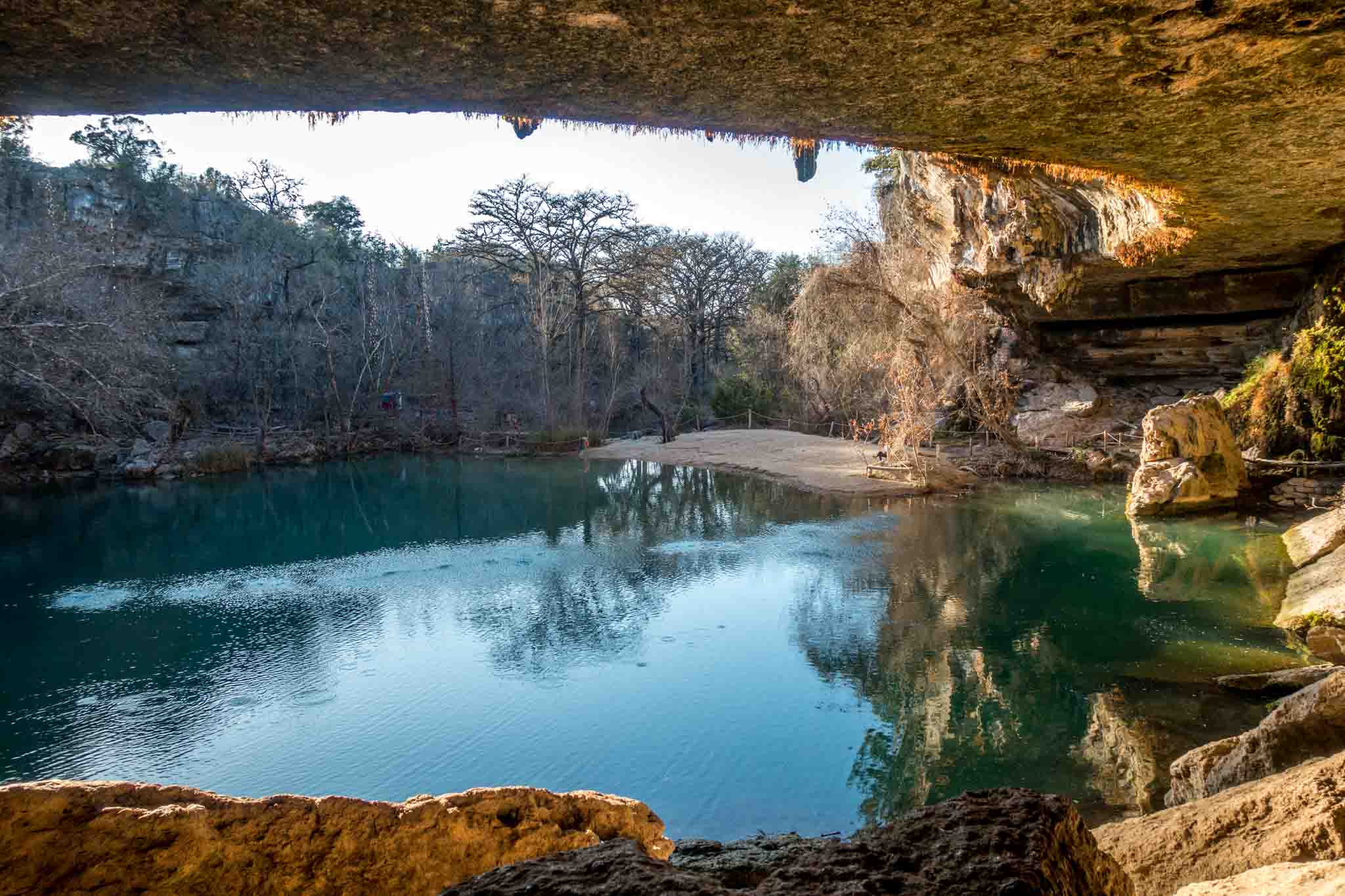 Hamilton Pool, a swimming hole surrounded by trees and a limestone wall