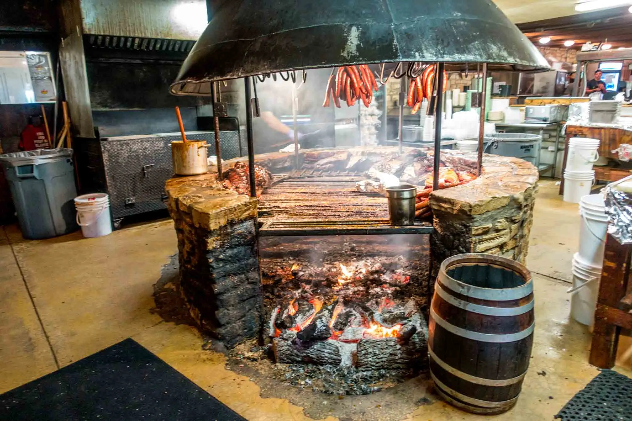 Sausage and meat cooking on a grill over a wood fire.