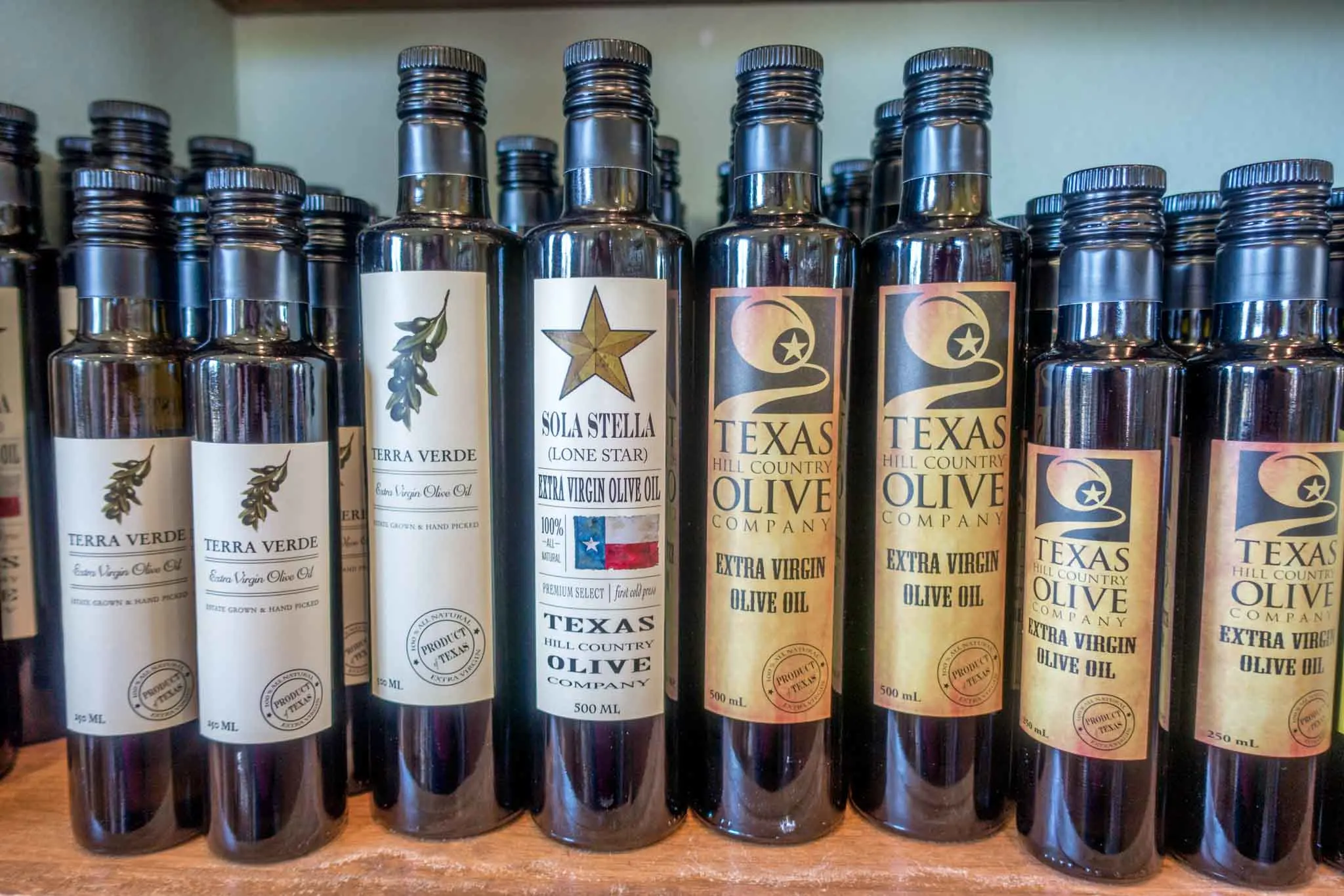 Bottles of olive oil on shelf.