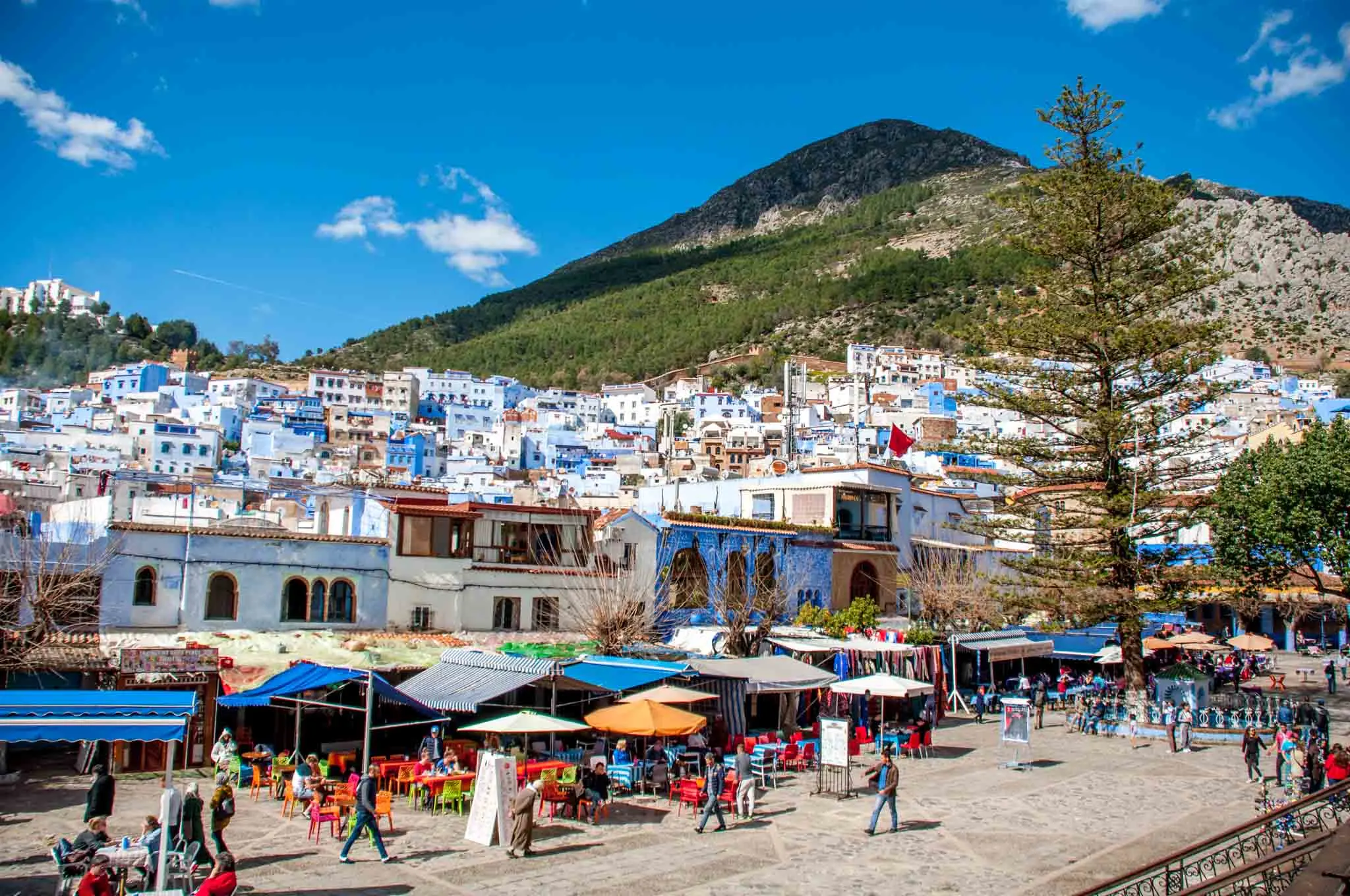 Blue and white buildings at the base of a mountain