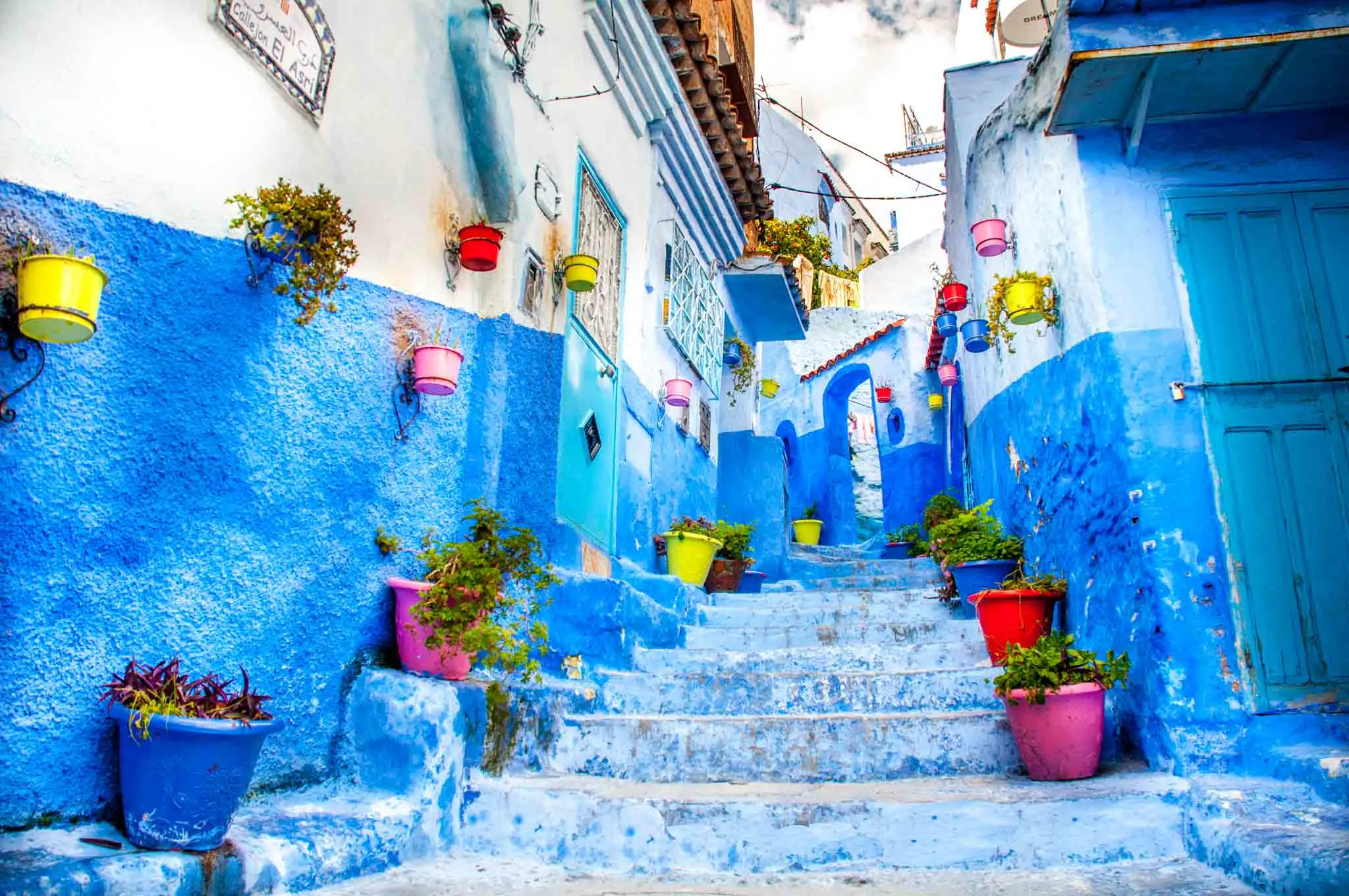 Blue staircase lined with colorful pots in Chefchaouen Morocco