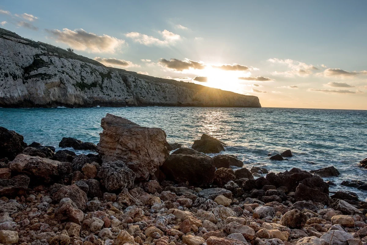 Sunset over the cliffs and water of Fomm ir-Rih Bay