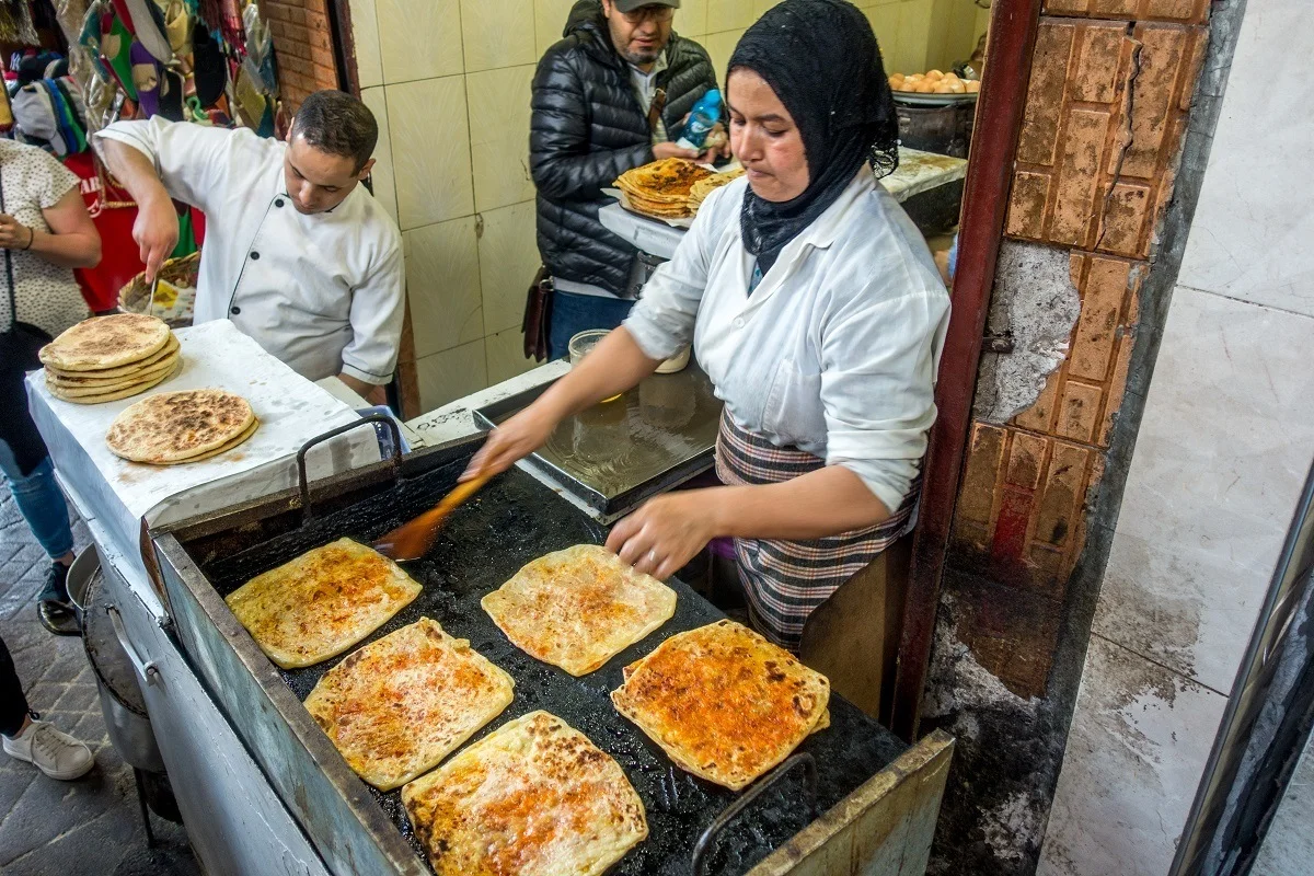 Woman cooking msemmen bread on a grill