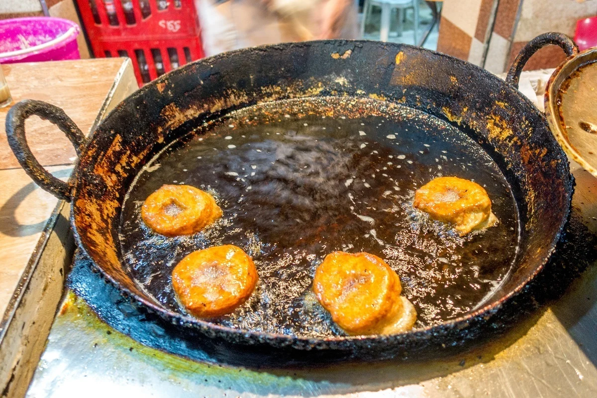 Sfenj, a donut-like treat, frying in oil