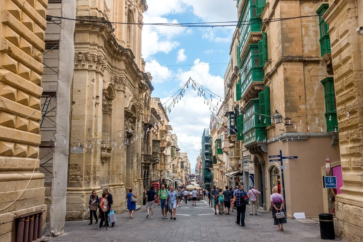 People walking down a street in Valletta