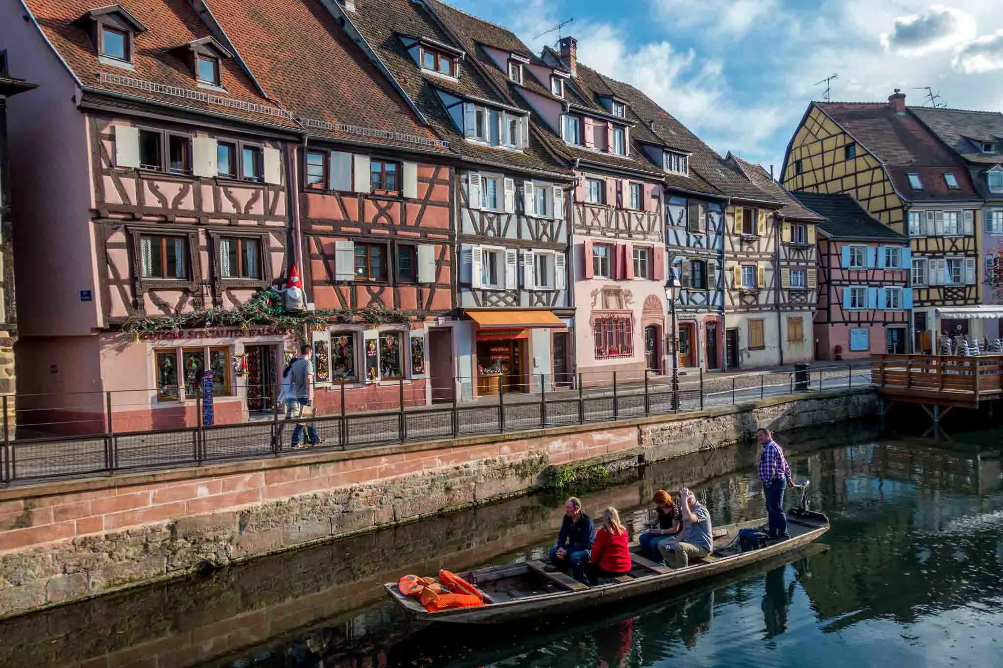 Boat in the river in front of a row of half-timbered buildings in Colmar
