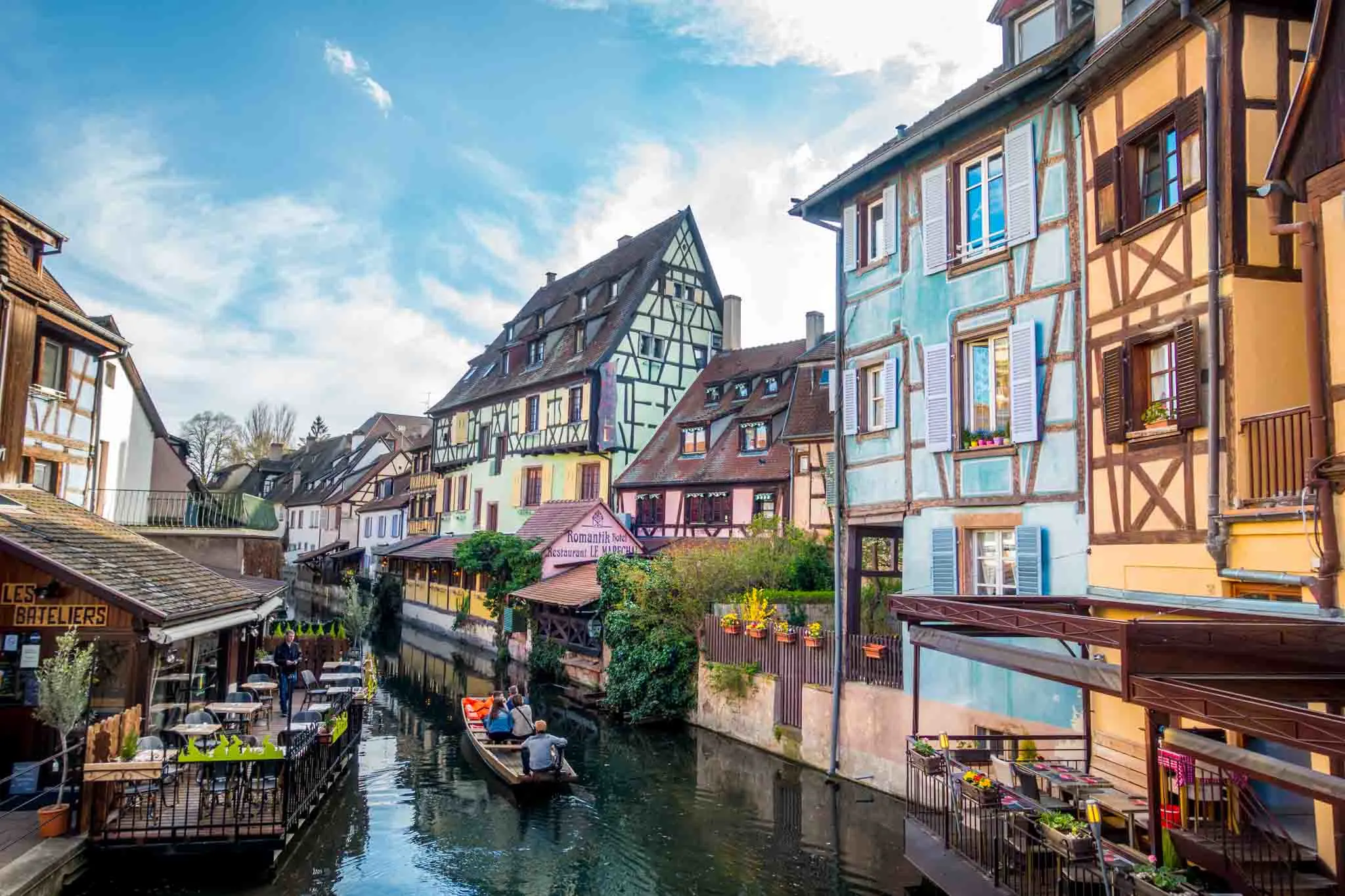 Boat floating by colorful half-timbered buildings.