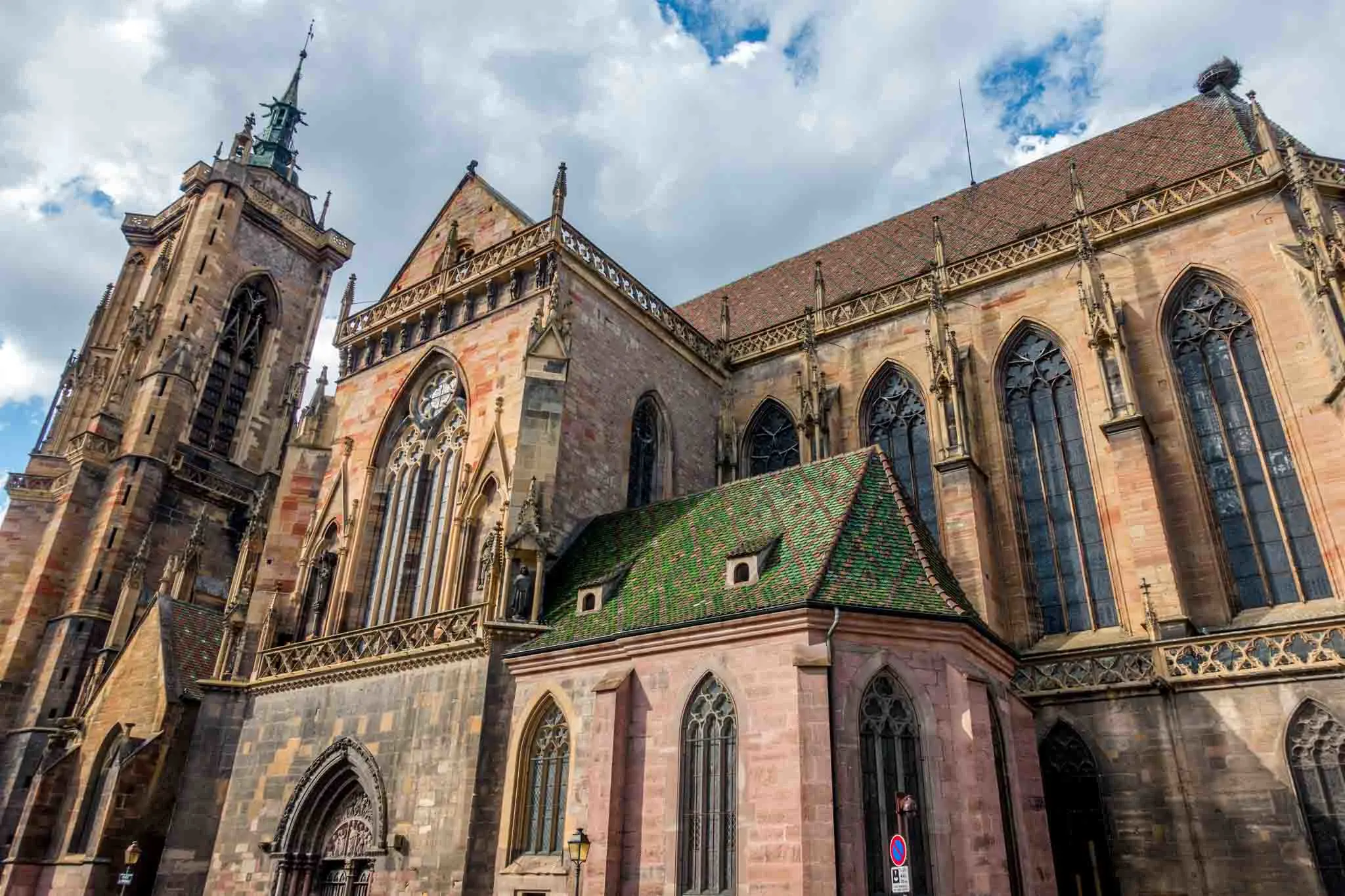 Church with spires and green tiled roof.