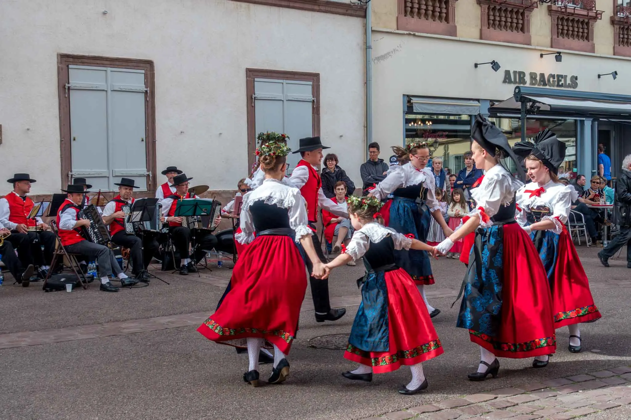 People dancing in traditional Alsatian clothing.