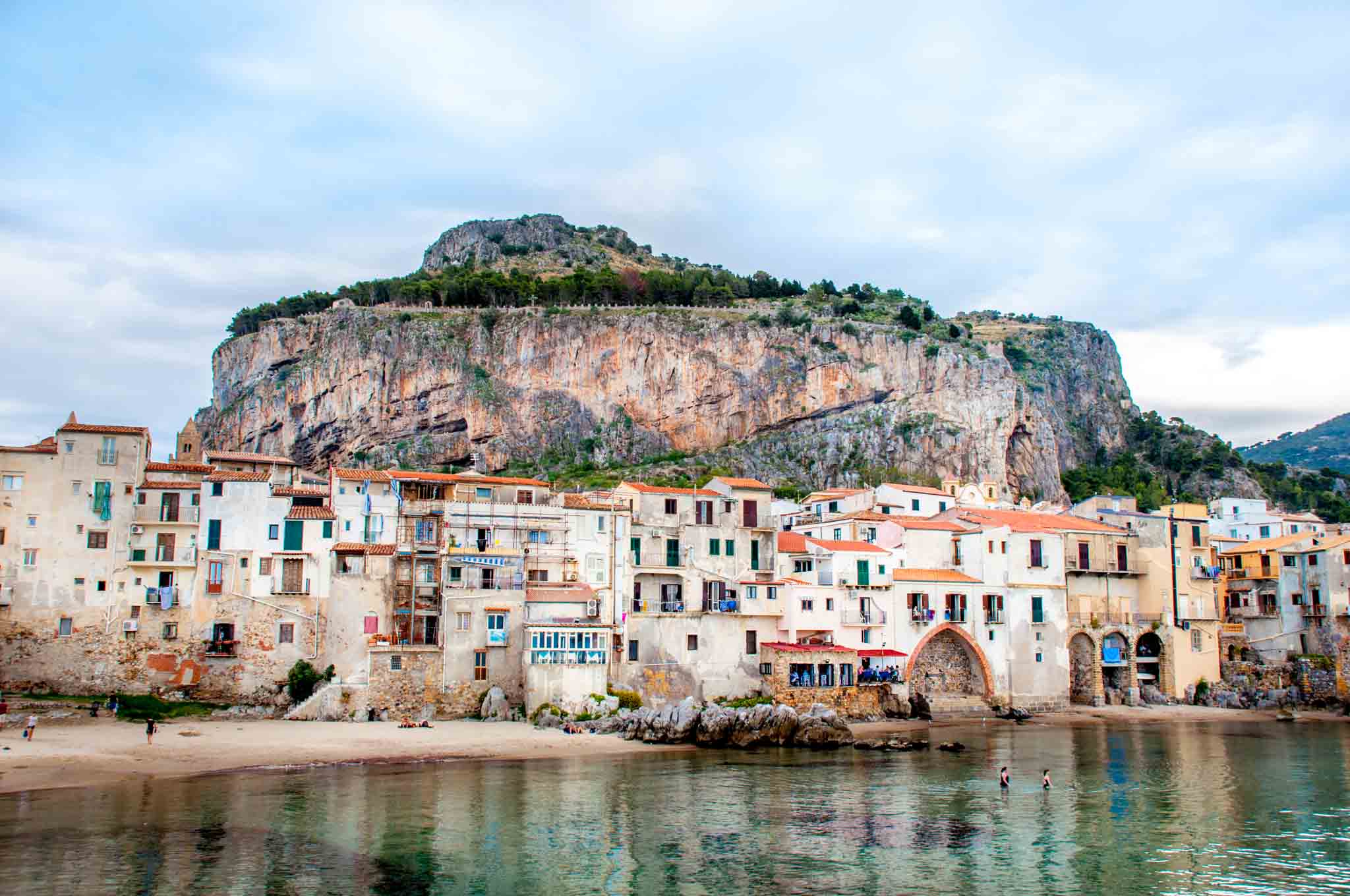 Seaside houses at the base of a large rock 