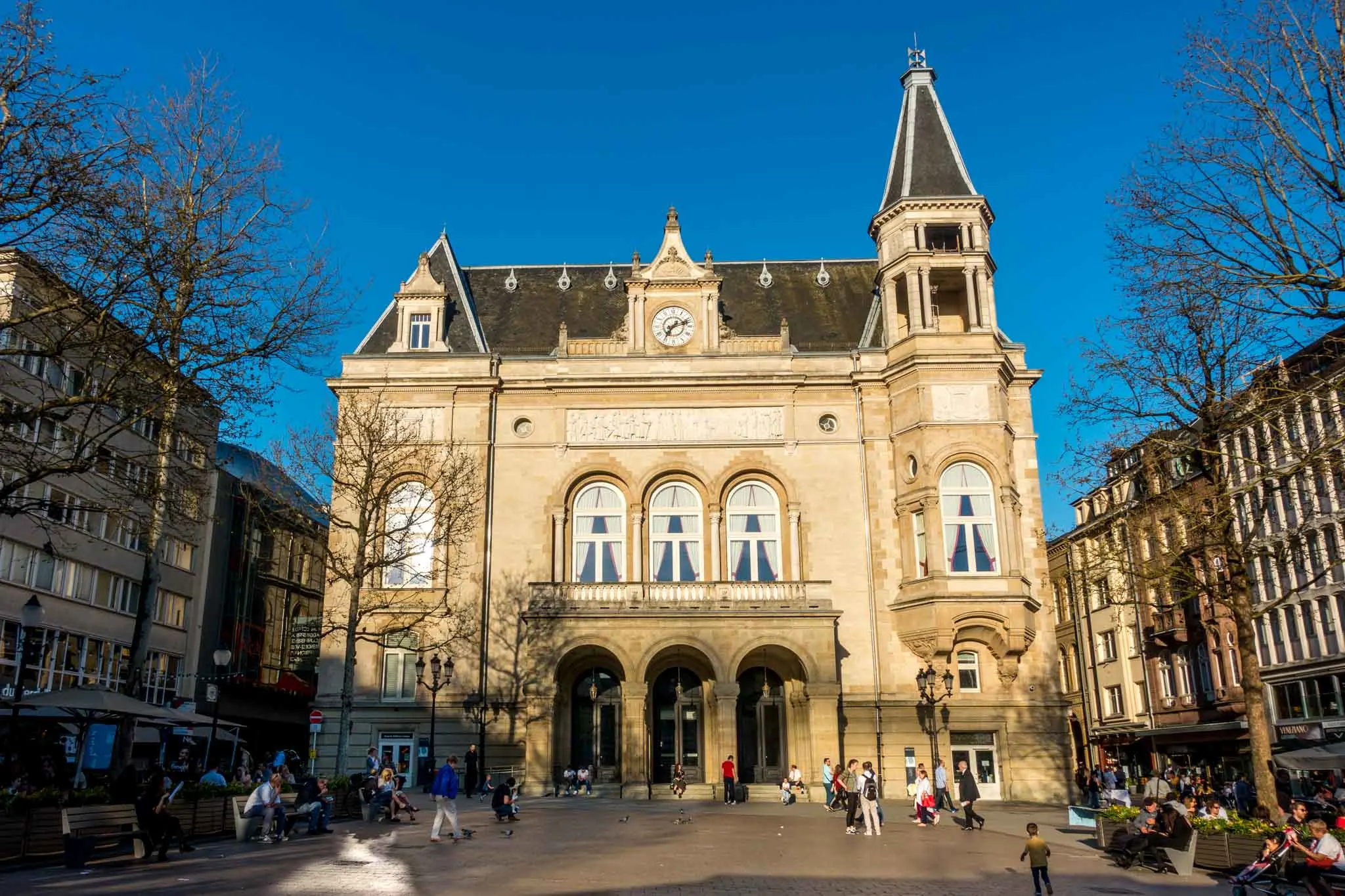 Building with arched doorway and windows on a city square.