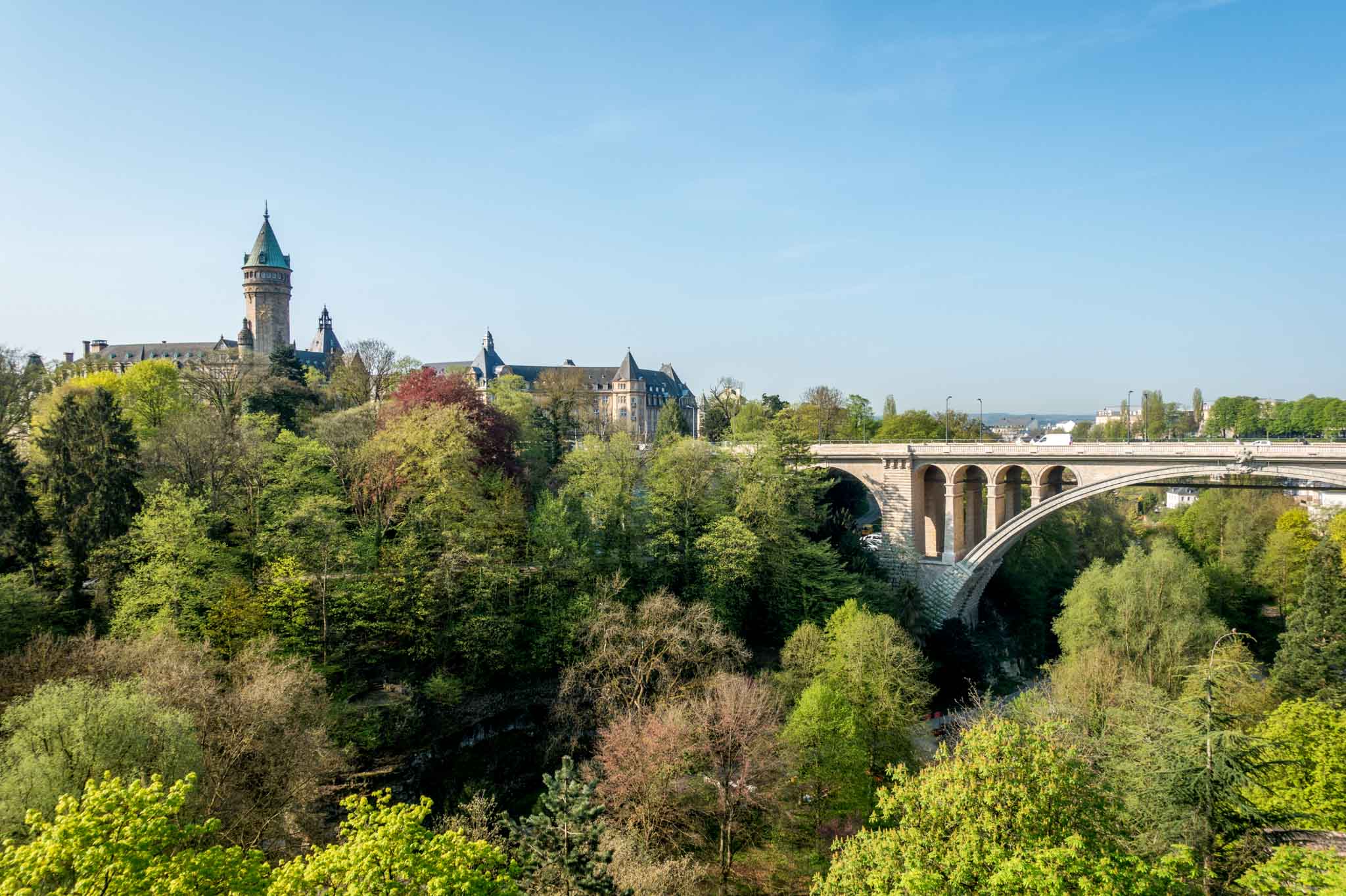 View of bridge and building across a tree-filled valley in Luxembourg City, Luxembourg.