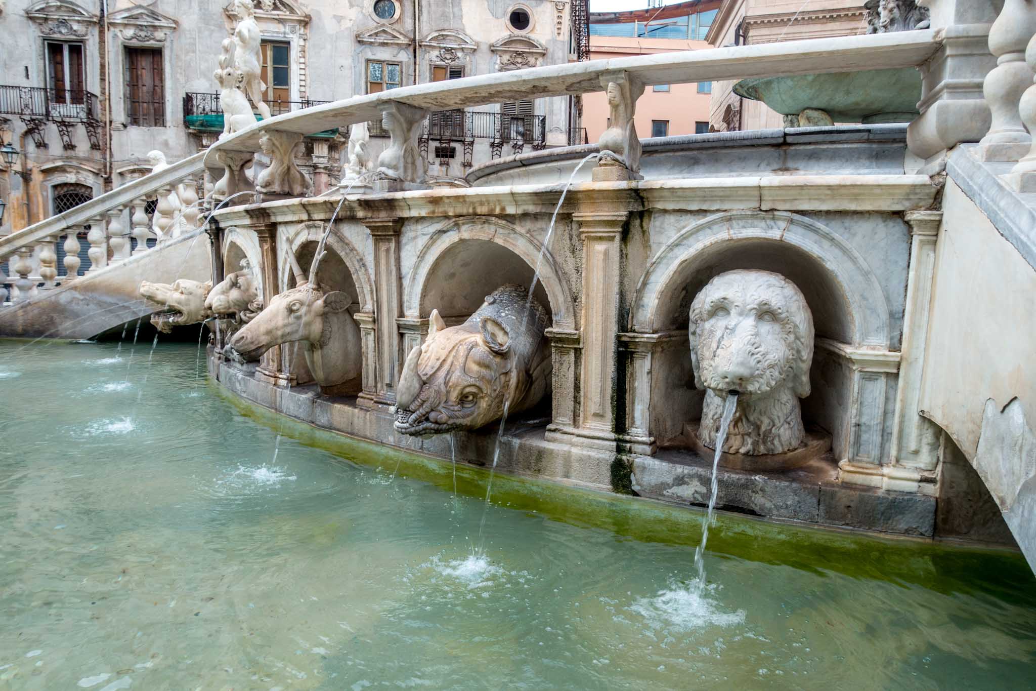 Animals spouting water at the base of fountain
