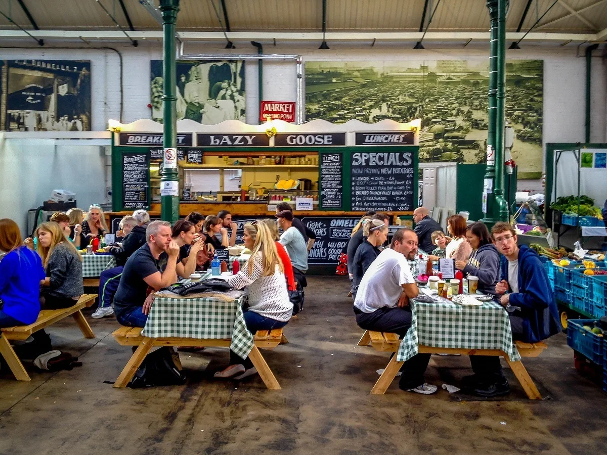 People eating at picnic tables in a food market