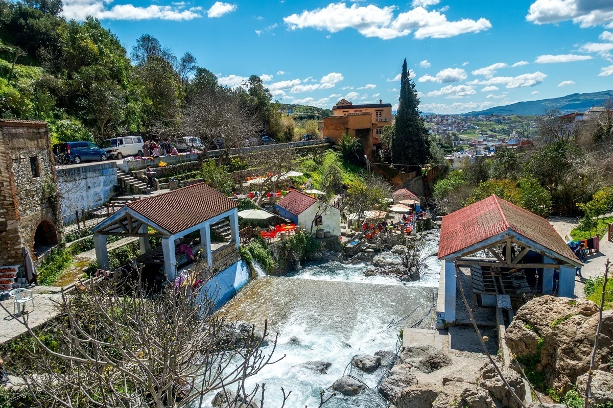 Cars on a road beside a manmade waterfall