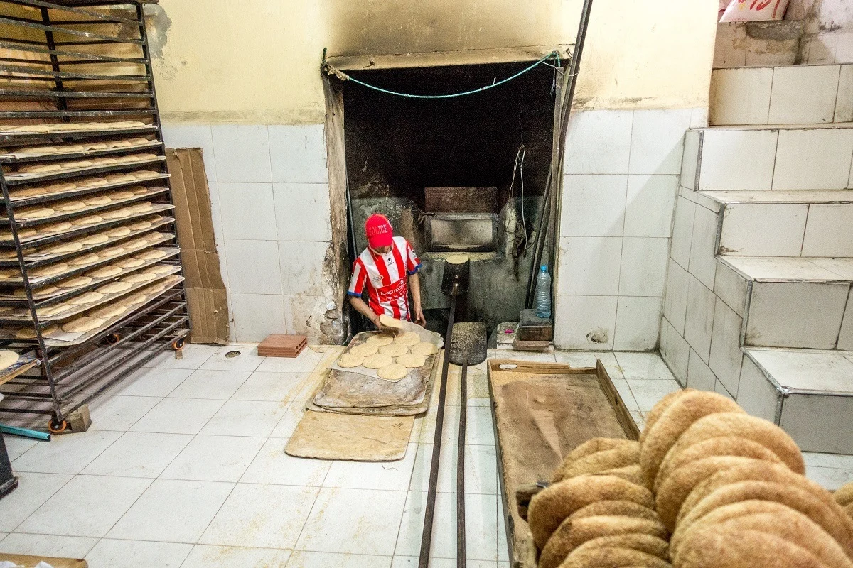 Man baking bread at community bakery in Morocco
