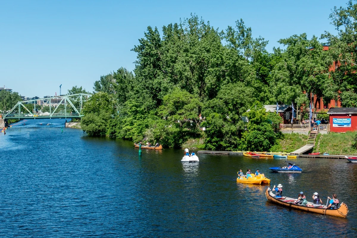 People in kayaks and peddle boats in a canal