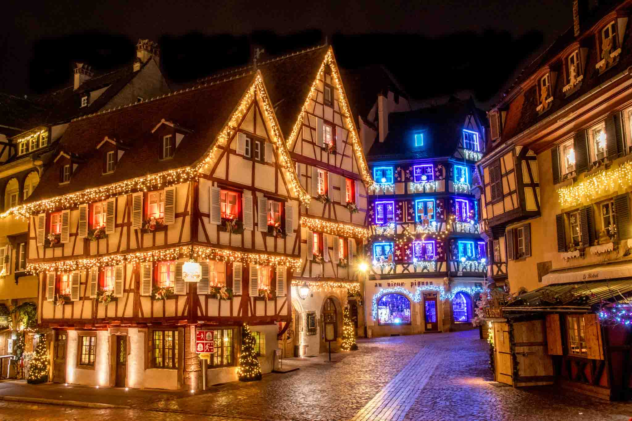 Half-timbered buildings lit up for Christmas.