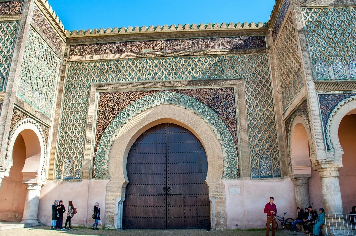 Massive wooden door at a city gate surrounded by Arabic tile.