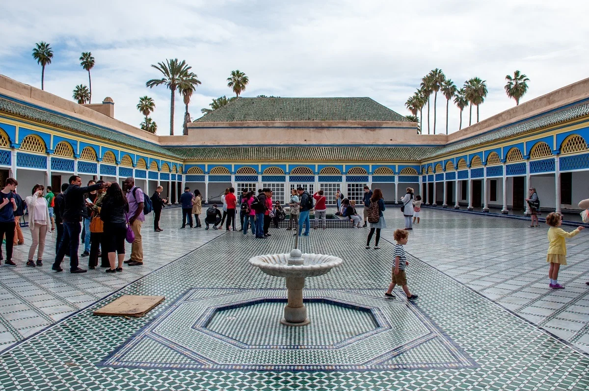 People in a tiled courtyard of a building.