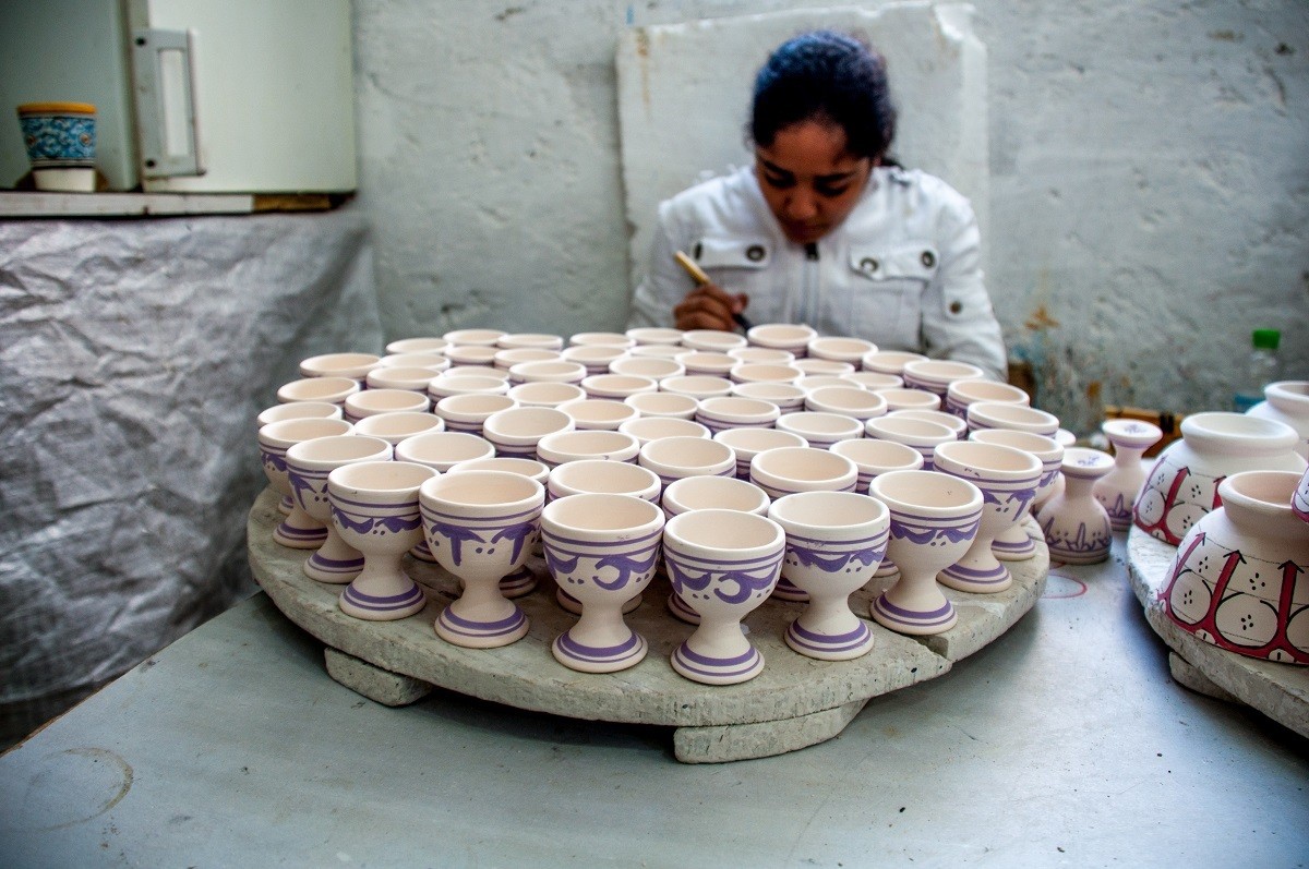 Girl painting pottery in a workshop.