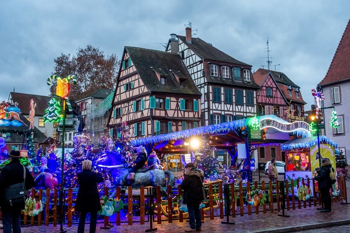Carnival rides beside half-timbered buildings