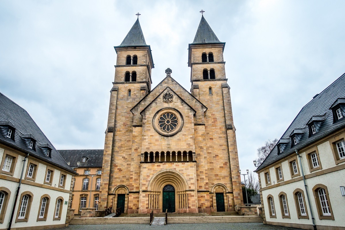 Church exterior with towers and stained glass, Echternach Abbey in Luxembourg