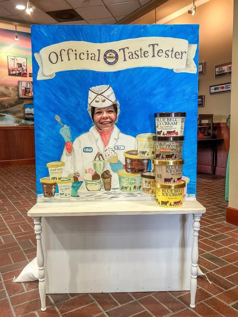 Woman behind photo cut out prop with Blue Bell ice cream containers