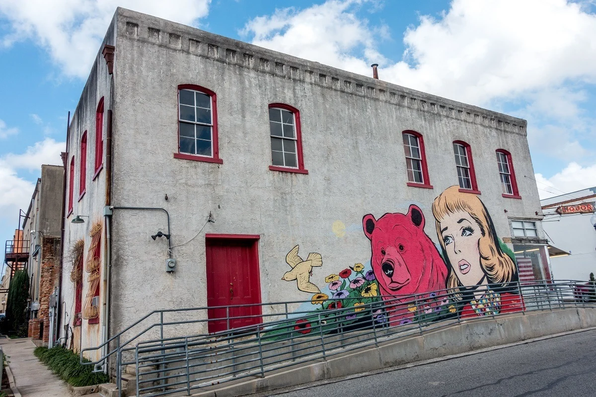 Building with mural including pink bear and woman
