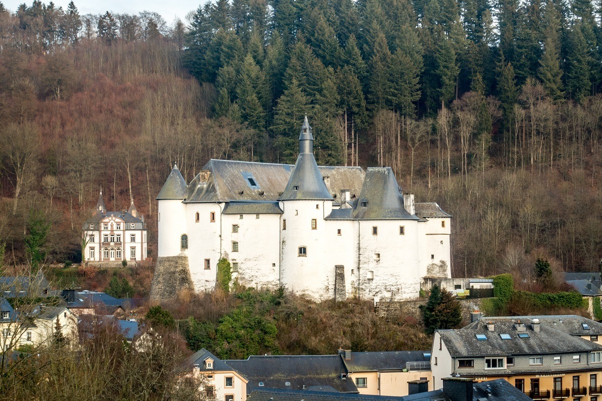 White castle surrounded by buildings and trees