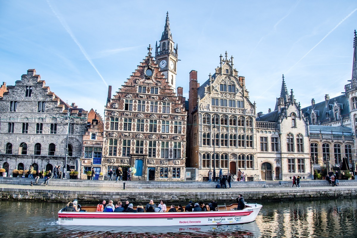 Boat cruising on the river in Ghent Belgium by historic buildings.