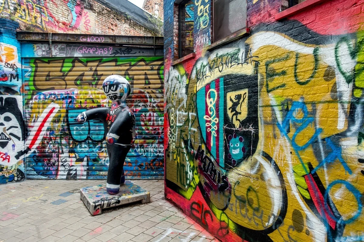 Graffiti-covered alley and spray painted sculpture